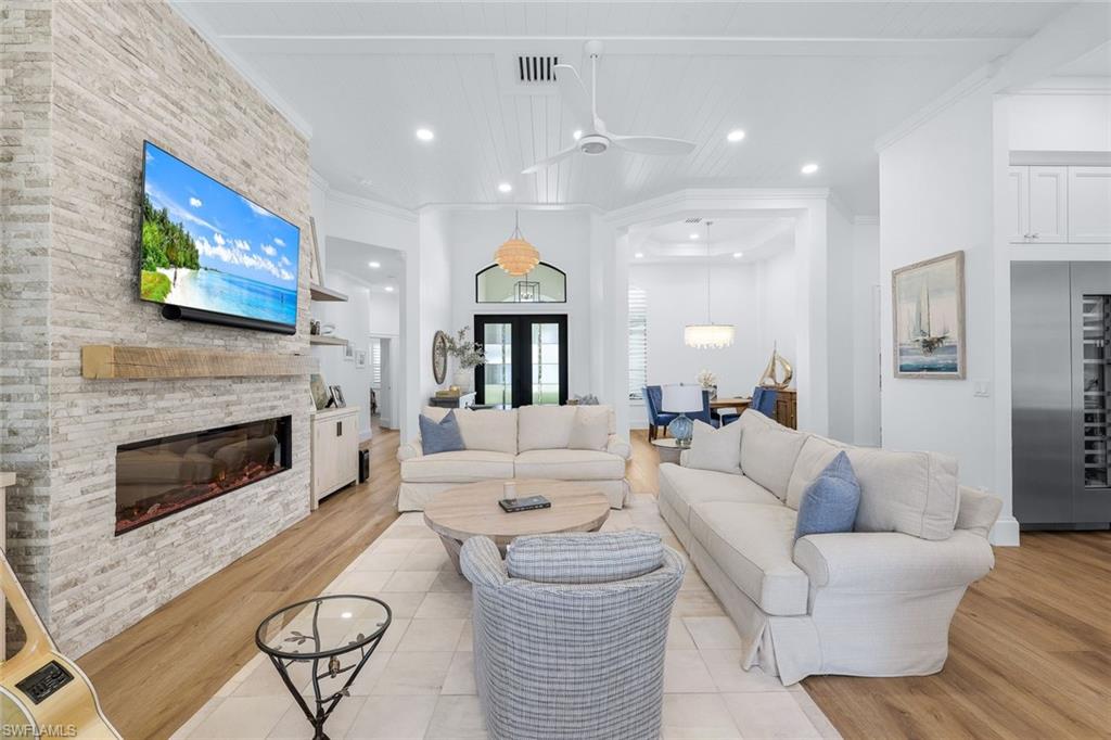 5092 Cerromar Drive Naples, FL 34112 - Photo 15 of 47 a living room with furniture a fireplace and a flat screen tv
