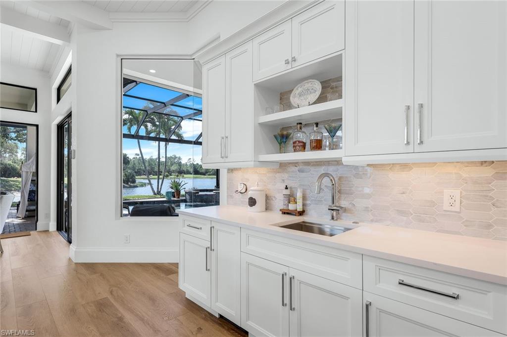 5092 Cerromar Drive Naples, FL 34112 - Photo 19 of 47 a kitchen with white cabinets and window