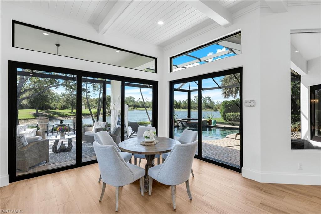 5092 Cerromar Drive Naples, FL 34112 - Photo 20 of 47 a dining room with furniture a chandelier and wooden floor