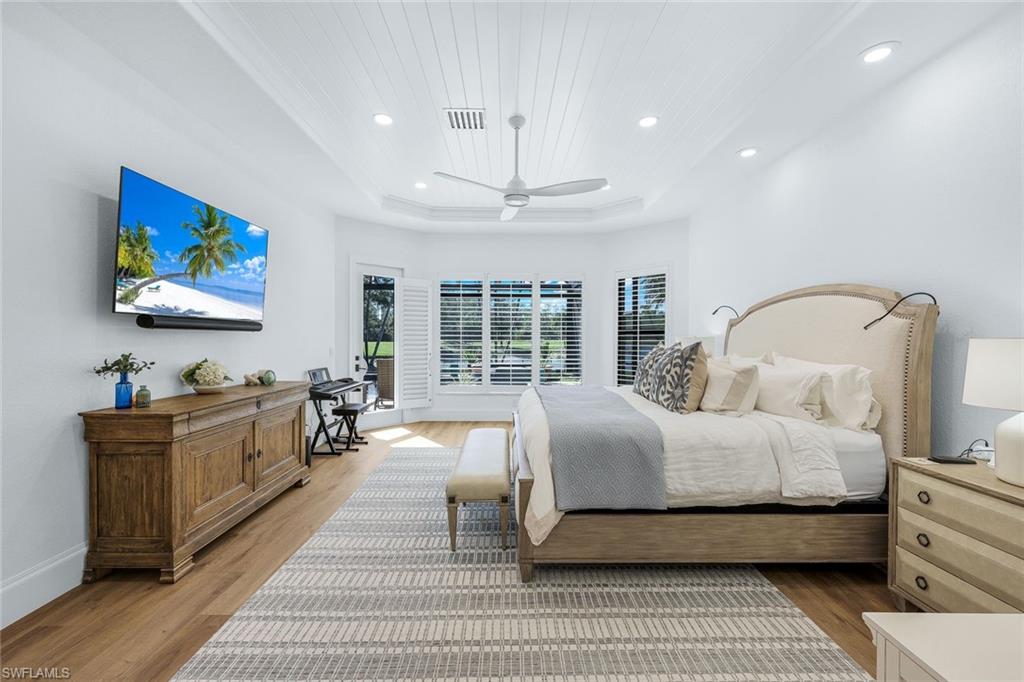5092 Cerromar Drive Naples, FL 34112 - Photo 23 of 47 a bedroom with a large bed and a flat screen tv