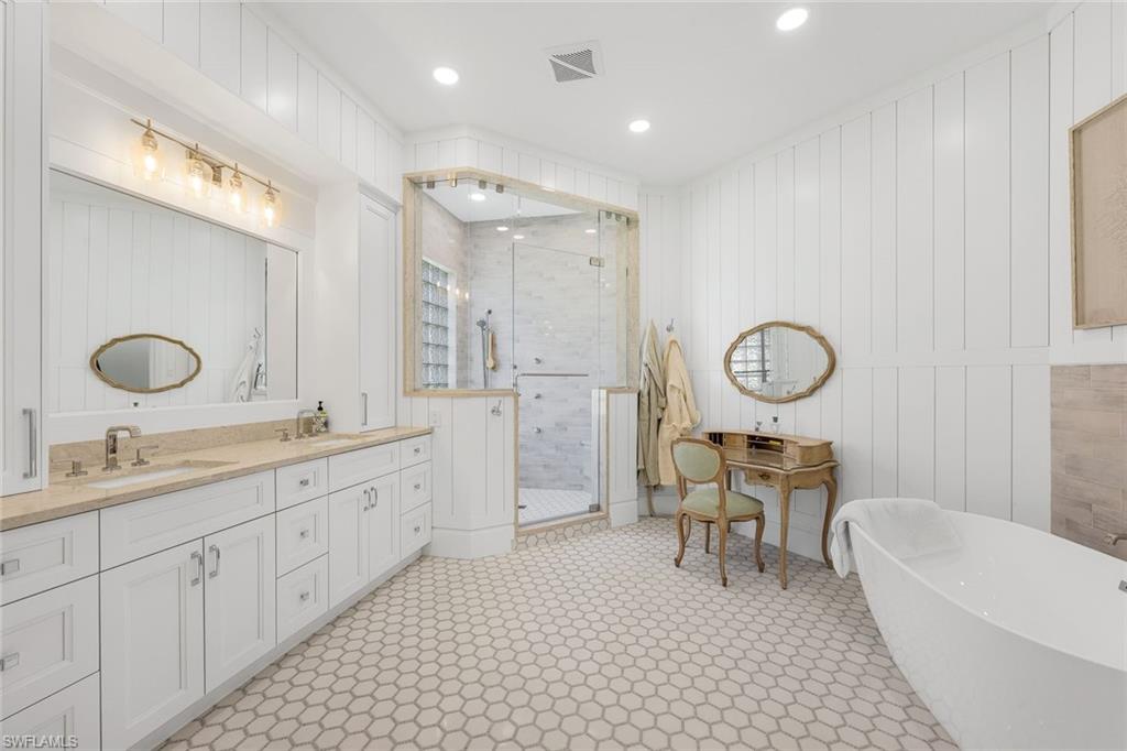 5092 Cerromar Drive Naples, FL 34112 - Photo 24 of 47 a large bathroom with a double vanity sink a toilet a mirror and shower