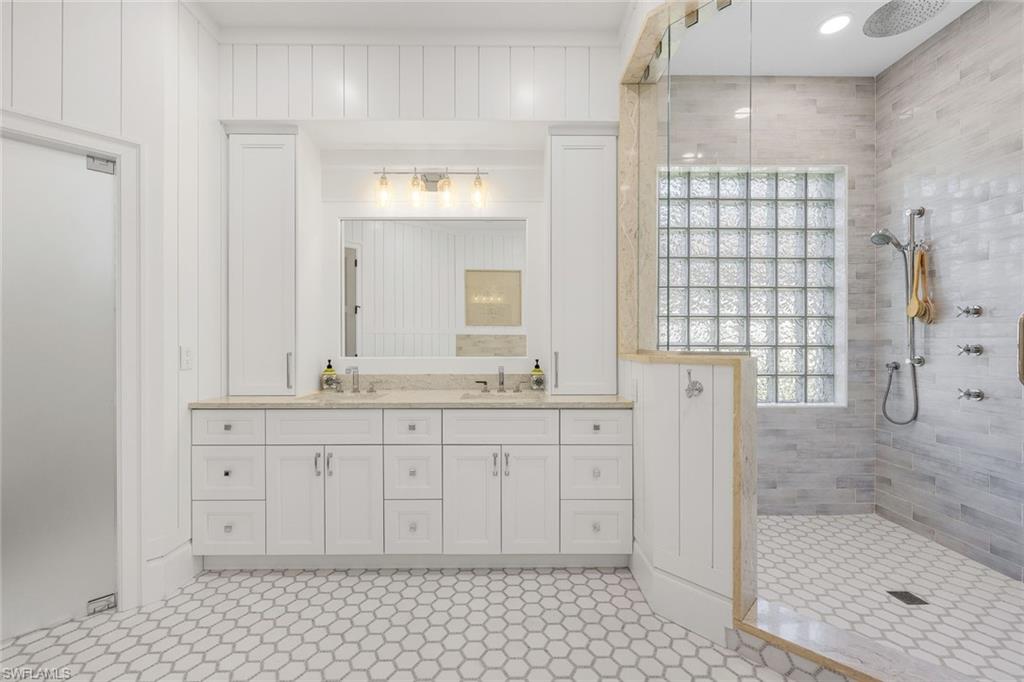 5092 Cerromar Drive Naples, FL 34112 - Photo 25 of 47 a bathroom with a granite countertop sink a mirror and shower