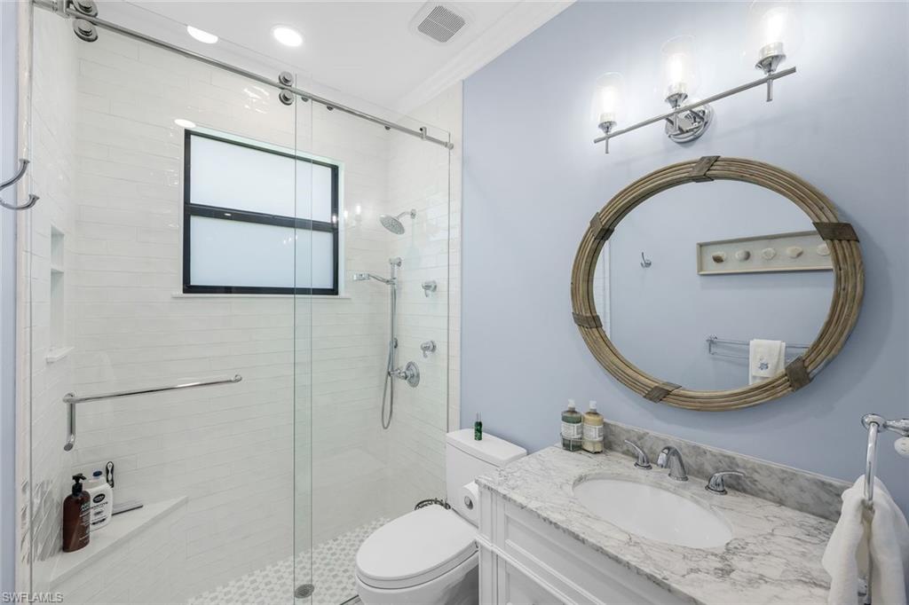 5092 Cerromar Drive Naples, FL 34112 - Photo 28 of 47 a bathroom with a granite countertop toilet a sink and a mirror