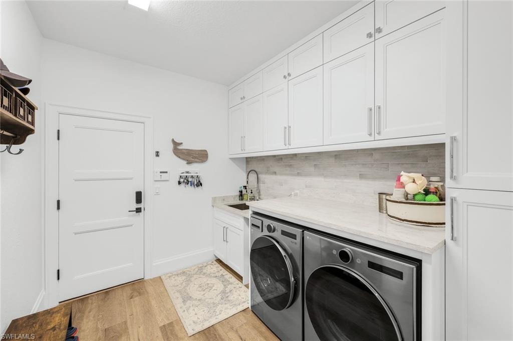 5092 Cerromar Drive Naples, FL 34112 - Photo 32 of 47 a utility room with sink dryer and washer