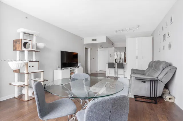 a living room with furniture a flat screen tv and kitchen view