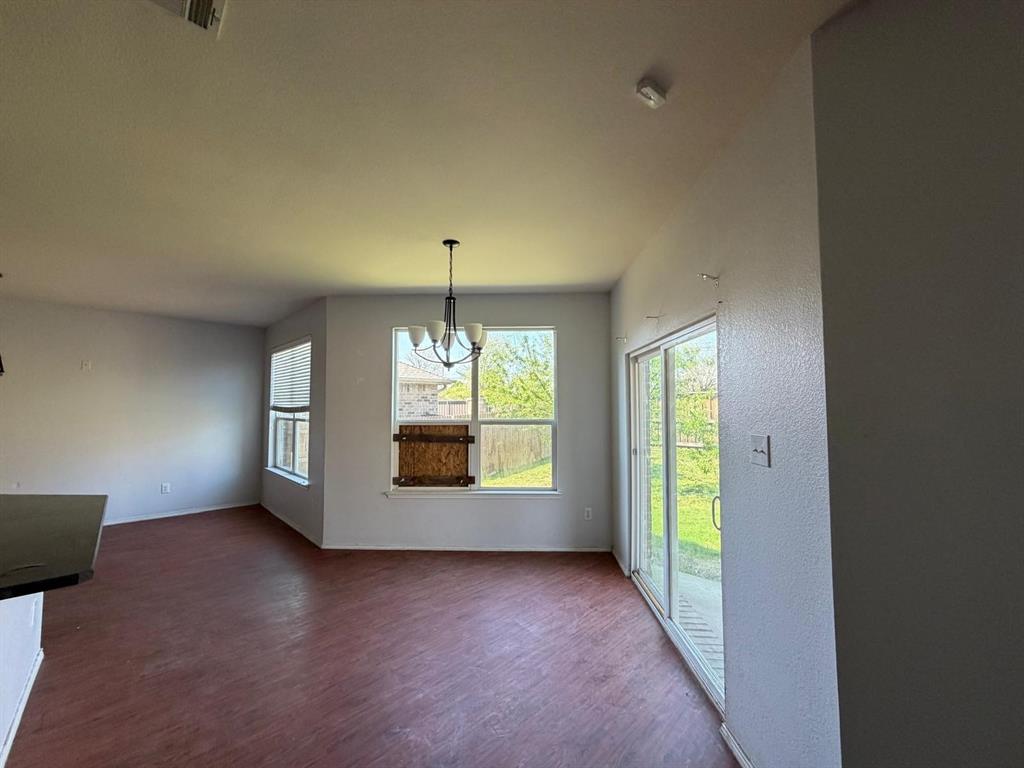 10400 Wagon Rut Court Fort Worth, TX 76108 - Photo 15 of 26 Unfurnished dining area with dark wood finished floors, healthy amount of natural light, and suspended lighting