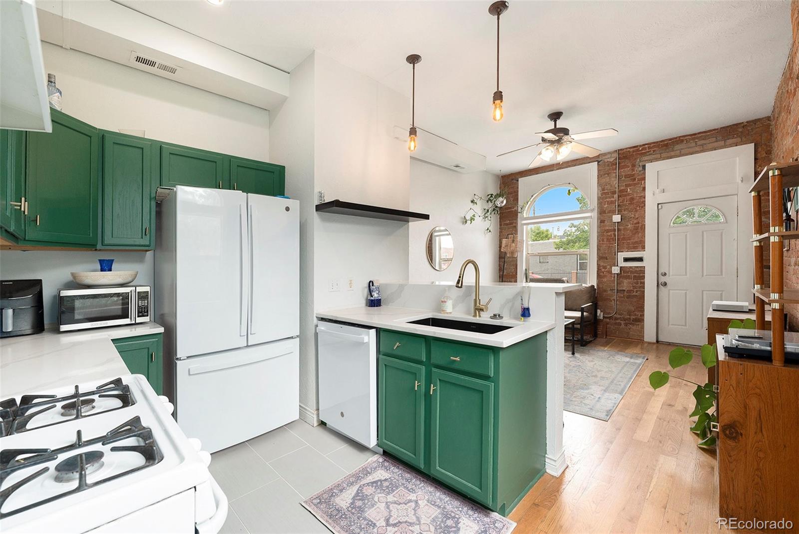 474 Inca Street Denver, CO 80204 - Photo 6 of 15 a kitchen with kitchen island a sink stove and refrigerator