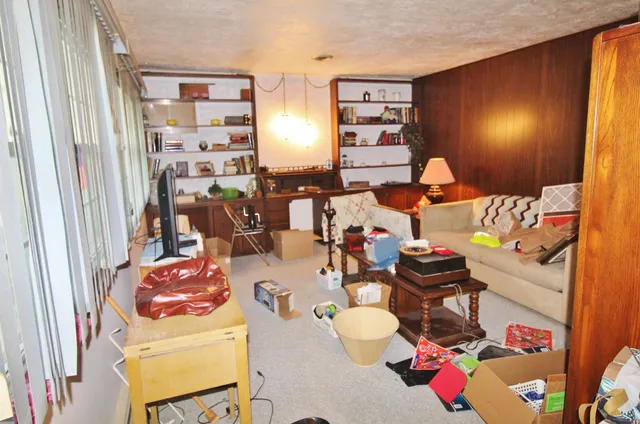 a living room with furniture and a floor to ceiling window