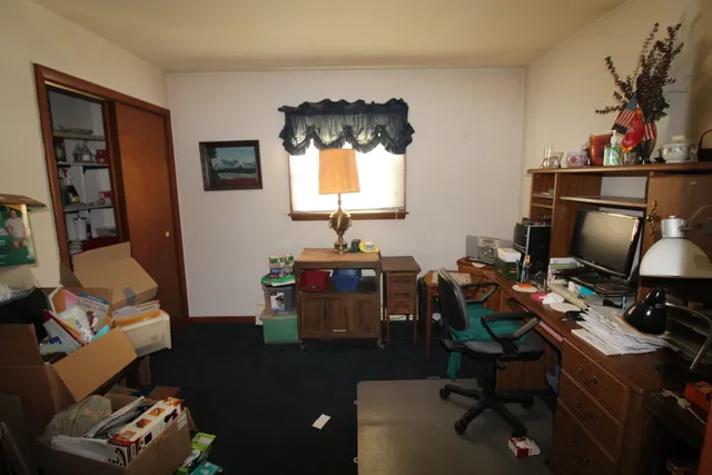 a view of a workspace with furniture and a window