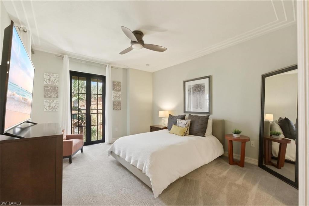9140 Delano Street, Unit 9302 Naples, FL 34113 - Photo 20 of 40 a bedroom with a large bed and a flat tv screen on dresser