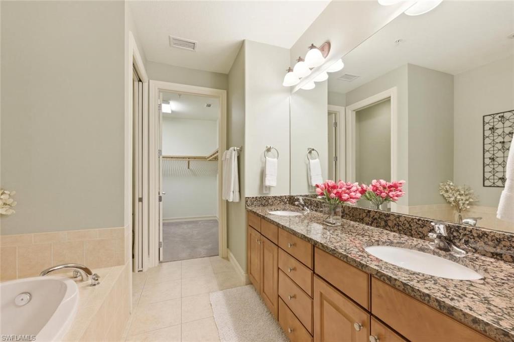 9140 Delano Street, Unit 9302 Naples, FL 34113 - Photo 24 of 40 a bathroom with a granite countertop double vanity sink mirror and shower