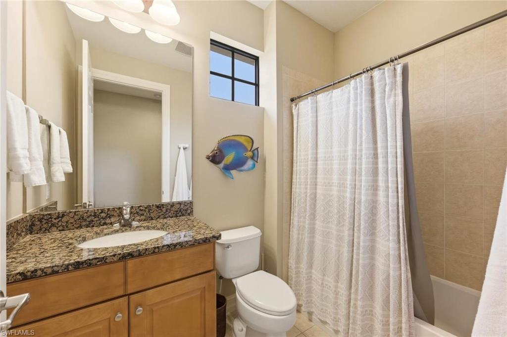 9140 Delano Street, Unit 9302 Naples, FL 34113 - Photo 27 of 40 a bathroom with a granite countertop sink toilet and shower