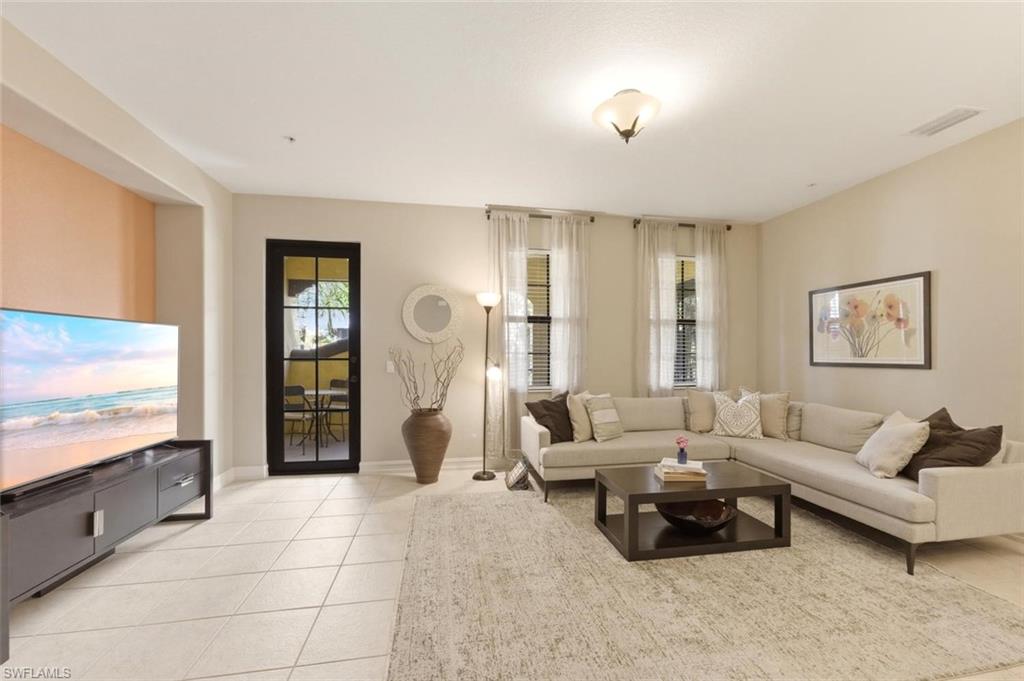 9140 Delano Street, Unit 9302 Naples, FL 34113 - Photo 10 of 40 a living room with furniture and a flat screen tv