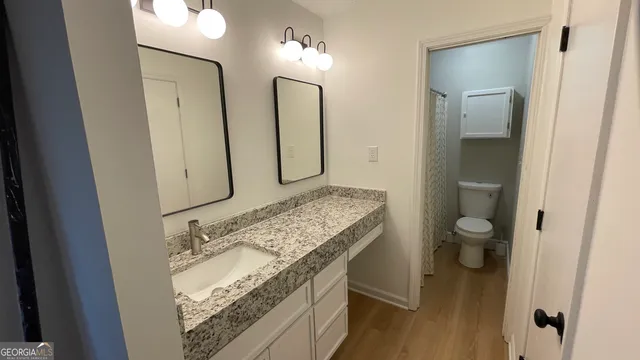 a bathroom with a granite countertop sink and a mirror