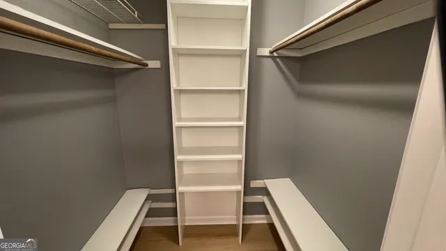 a view of walk in closet with empty racks