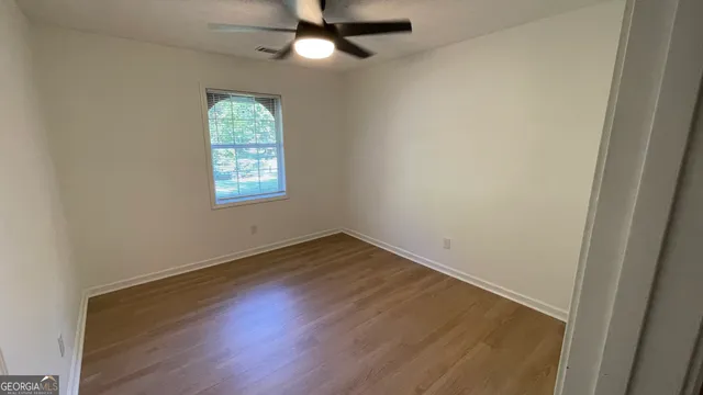 an empty room with a window and wooden floor