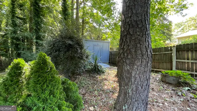 a view of a house with backyard and trees