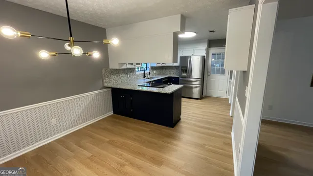 a kitchen with stainless steel appliances granite countertop a sink and a refrigerator