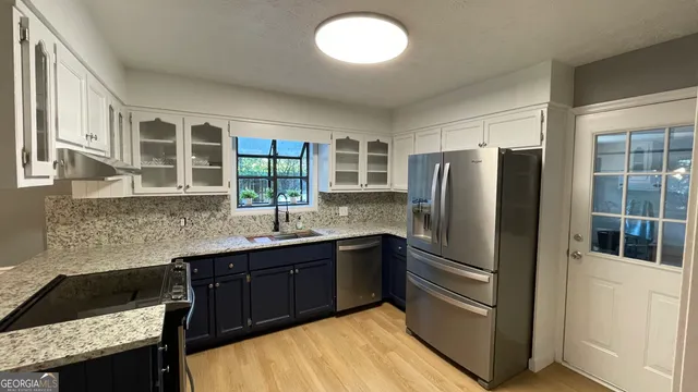 a kitchen with stainless steel appliances granite countertop a refrigerator and a sink