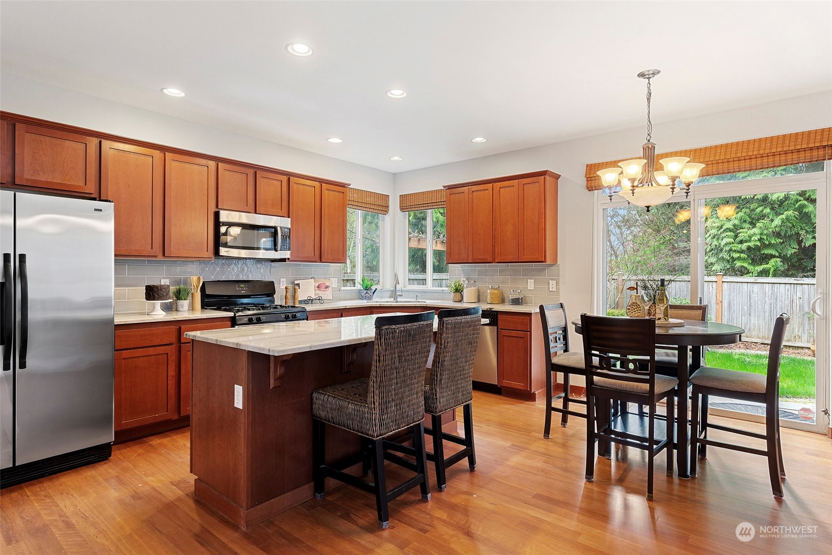4518 147th Place Southeast Bothell, WA 98012 - Photo 7 of 36 a kitchen with stainless steel appliances granite countertop a table chairs sink refrigerator and microwave