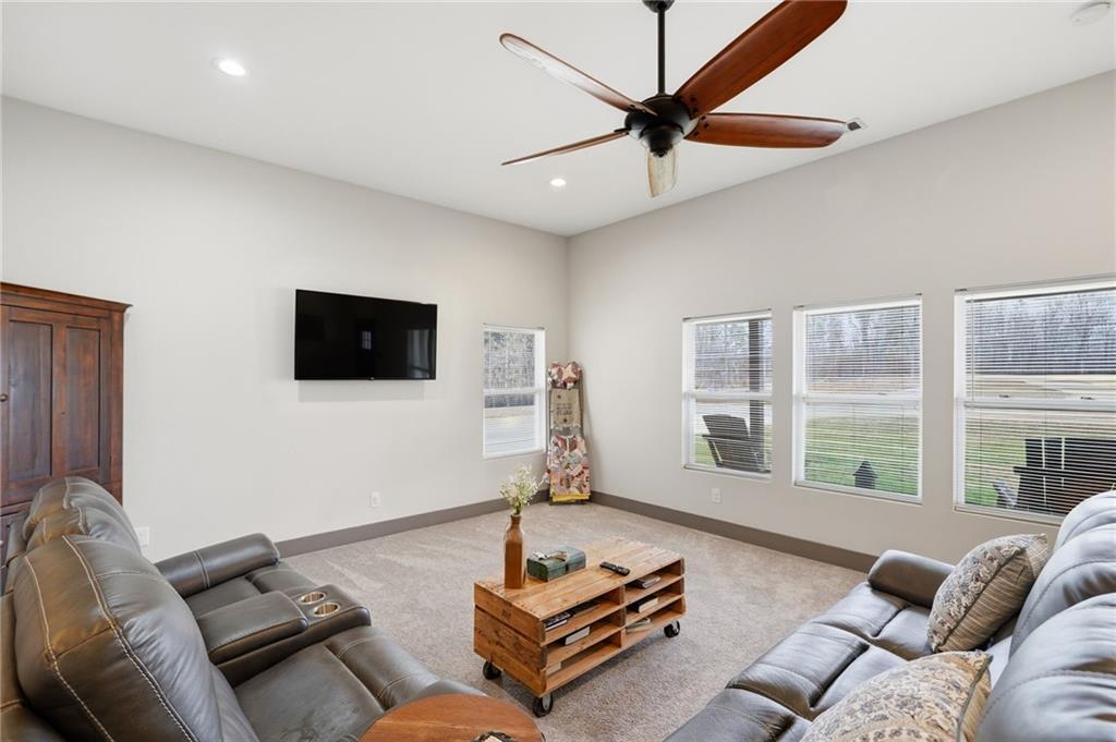 1100 Soap Creek Road Ball Ground, GA 30107 - Photo 75 of 107 a living room with furniture a large window and a flat screen tv