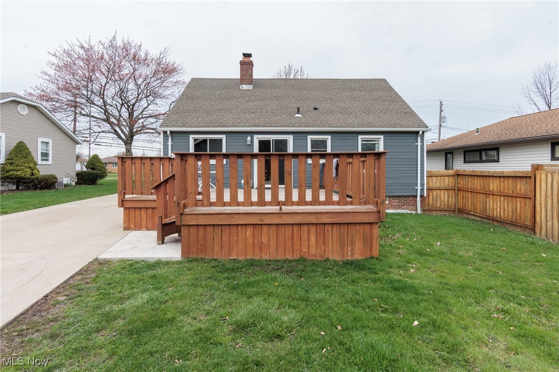 3443 Dentzler Road Parma, OH 44134 - Photo 5 of 48 Rear view of property featuring fence, a deck, a shingled roof, a yard, and a chimney