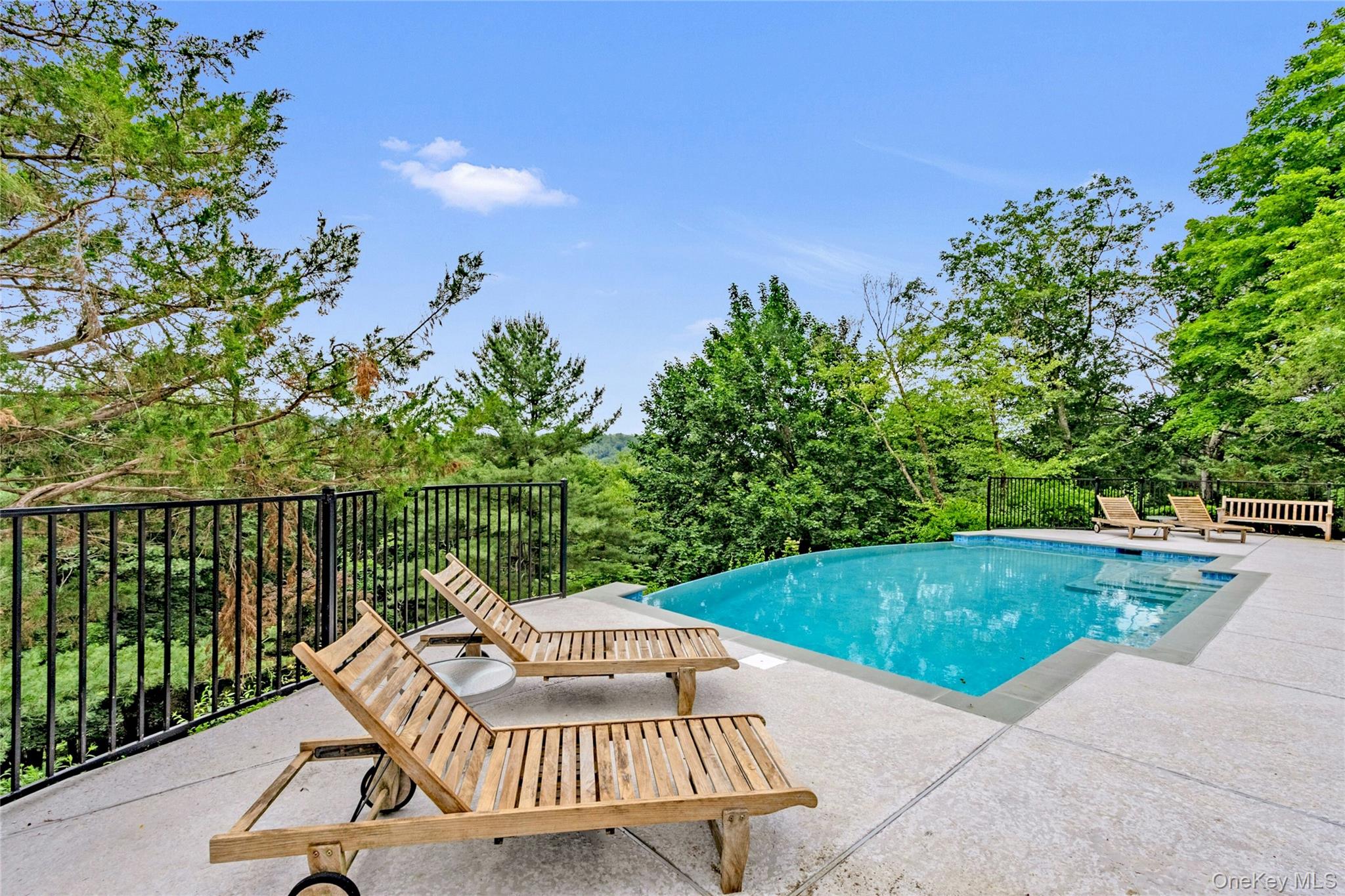 94 Cliff Road Tuxedo Park, NY 10987 - Photo 2 of 37 a view of a swimming pool with a patio and a garden