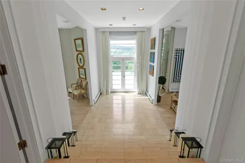 a view of a hallway with dining area and chandelier