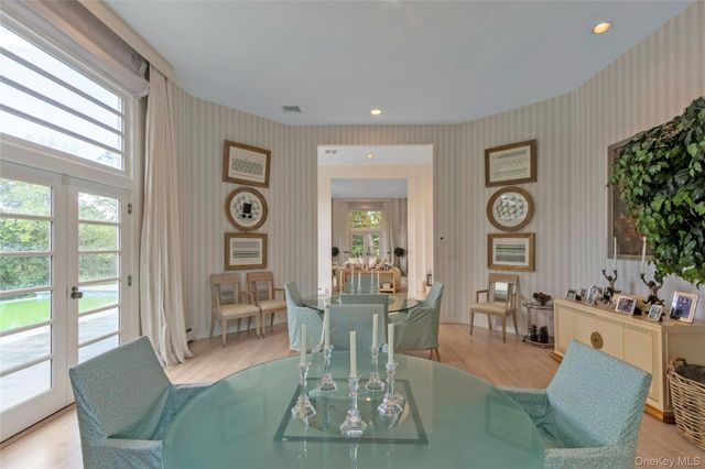 a kitchen with stainless steel appliances granite countertop a dining table chairs and white cabinets