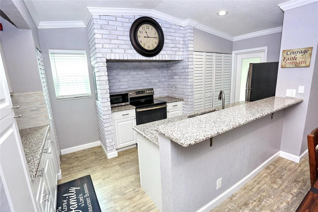 6960 Southwest 1st Street Margate, FL 33068 - Photo 13 of 36 a kitchen with a stove and a clock