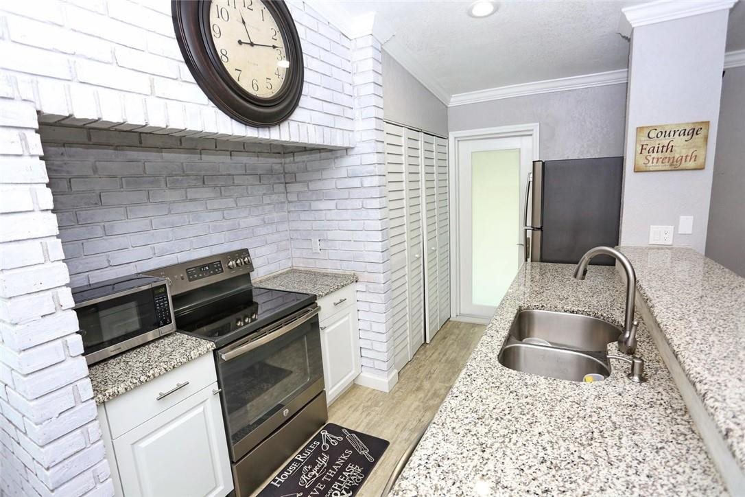 6960 Southwest 1st Street Margate, FL 33068 - Photo 14 of 36 a kitchen with a stove a sink and a microwave