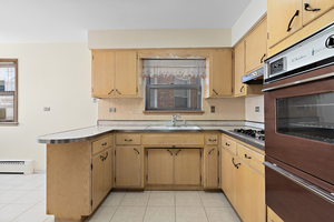 5705 West Higgins Avenue, Unit 2 Chicago, IL 60630 - Photo 4 of 12 a kitchen with a sink stove and cabinets