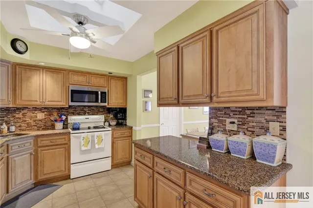 a kitchen with stainless steel appliances granite countertop a stove a microwave and cabinets