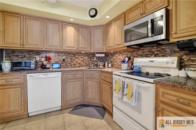 a kitchen with granite countertop a table chairs stove and cabinets