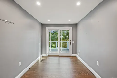 an empty room with wooden floor and sliding door