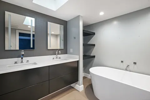 a bathroom with a double vanity sink mirror and toilet