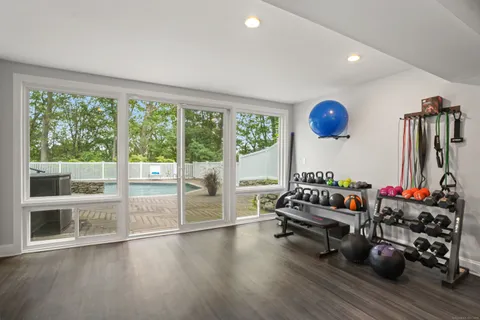 a living room with furniture a flat screen tv and a large window
