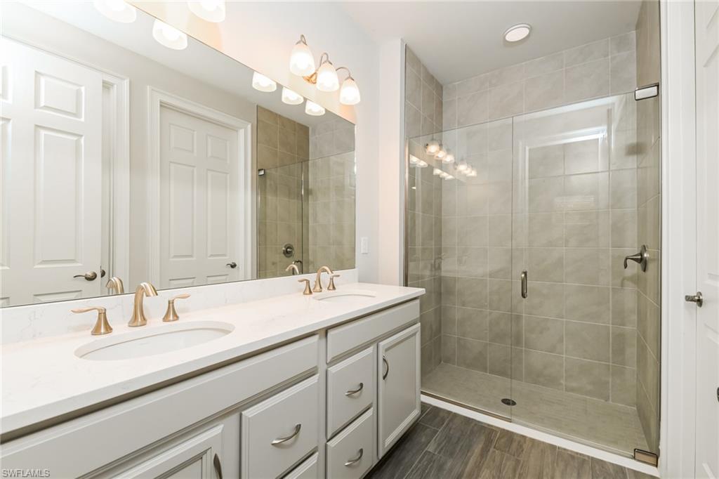 1059 Enbrook Loop Naples, FL 34114 - Photo 11 of 19 Full bath featuring double vanity and a stall shower