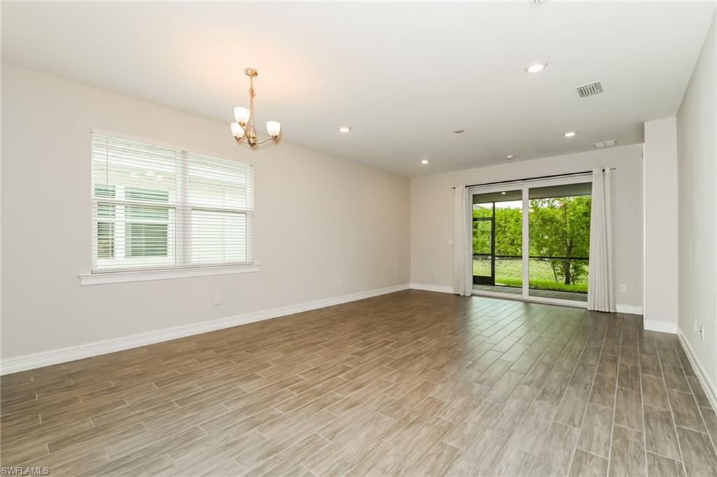 1059 Enbrook Loop Naples, FL 34114 - Photo 5 of 19 Spare room with plenty of natural light, wood finish floors, recessed lighting, and a chandelier