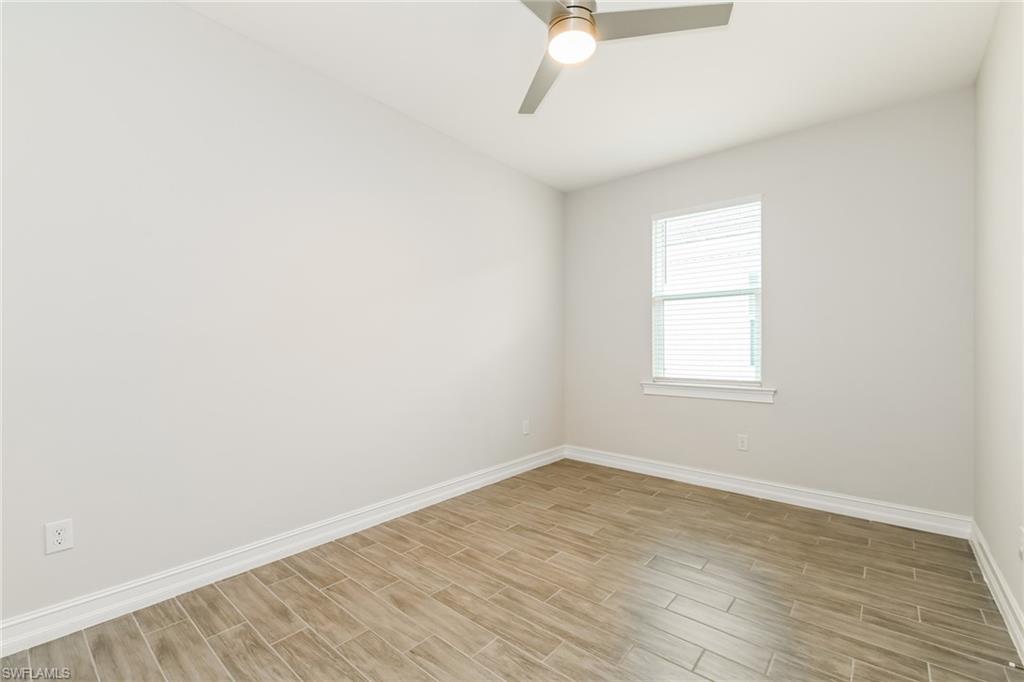 1059 Enbrook Loop Naples, FL 34114 - Photo 8 of 19 Empty room with wood tiled floors and ceiling fan