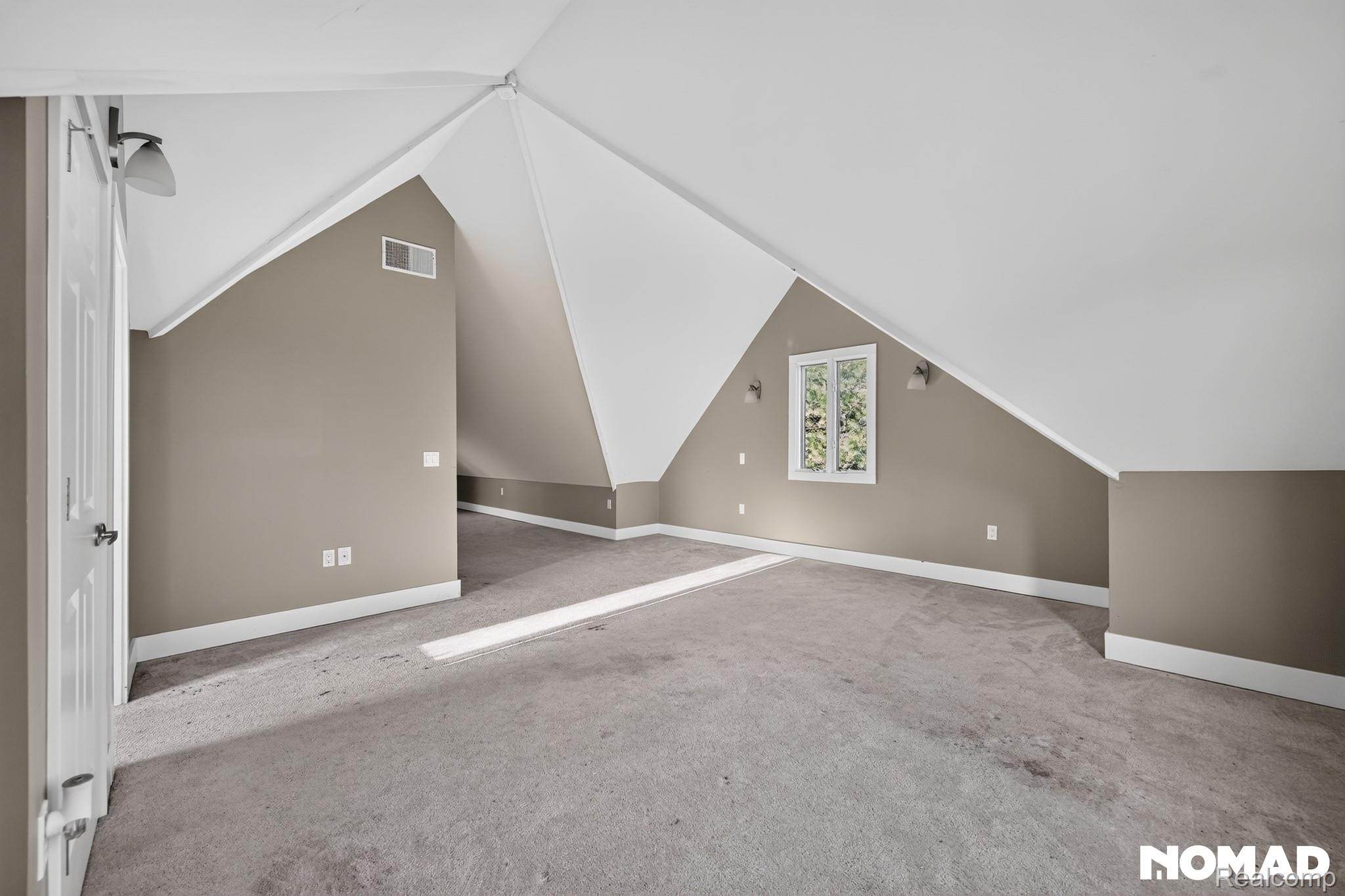 8315 Hilton Road Brighton, MI 48114 - Photo 14 of 26 Expansive carpeted room featuring sloped ceilings, neutral wall tones, and recessed window