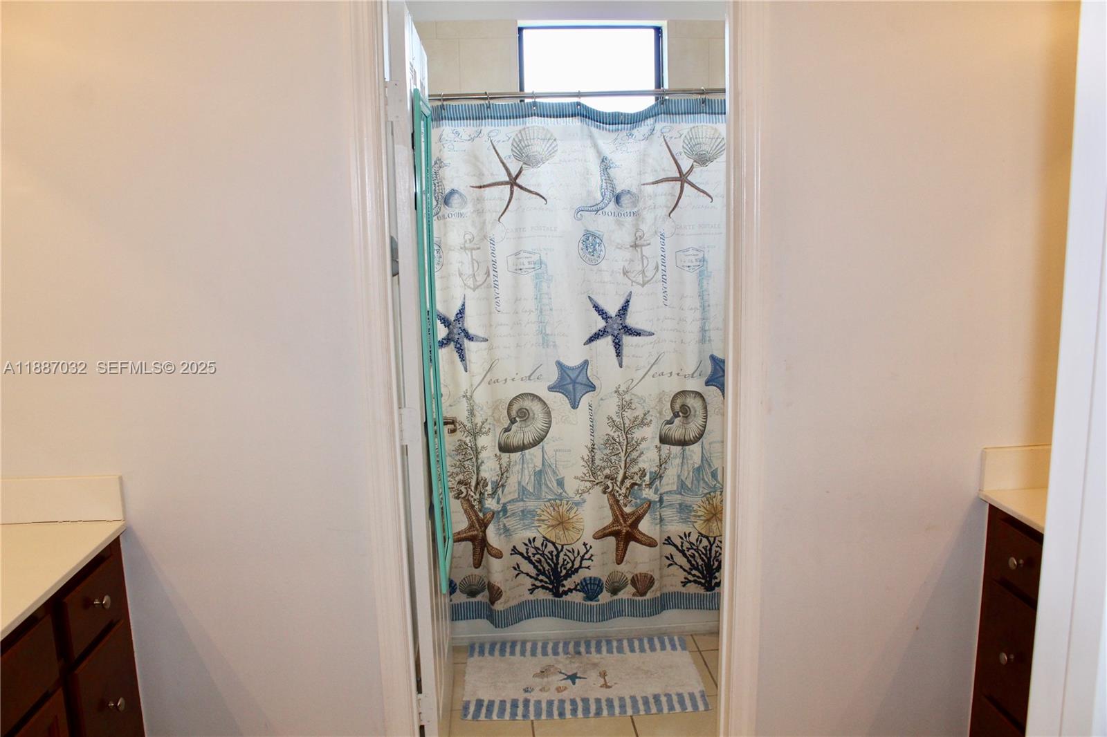 3728 Southeast 5th Court Homestead, FL 33033 - Photo 19 of 26 a picture of a bathroom with a vanity and a shower curtain