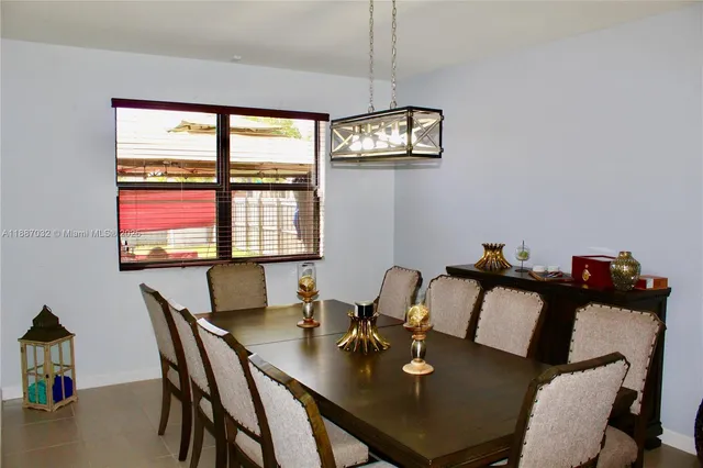 a kitchen with stainless steel appliances granite countertop a dining table chairs sink refrigerator and microwave