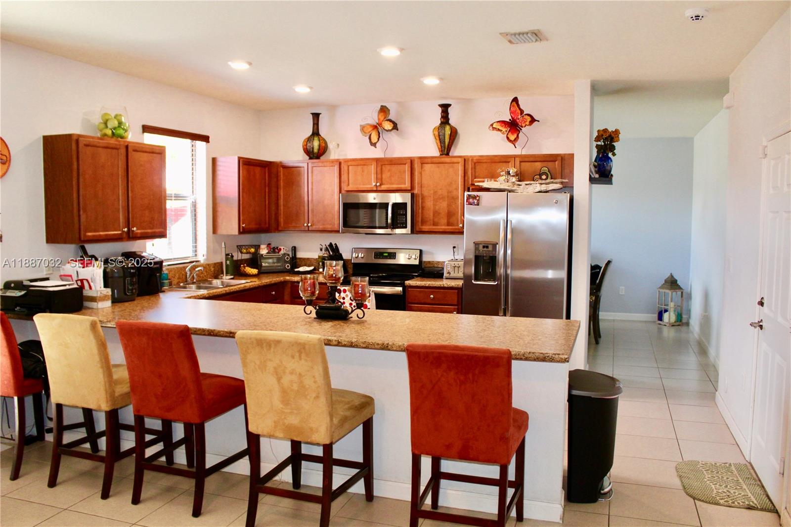 3728 Southeast 5th Court Homestead, FL 33033 - Photo 5 of 26 a kitchen with stainless steel appliances granite countertop a dining table chairs sink refrigerator and microwave