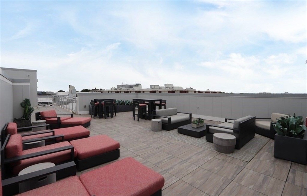 1973 Dorchester Avenue, Unit 5004 Boston, MA 02124 - Photo 14 of 15 a roof deck with couch and chairs