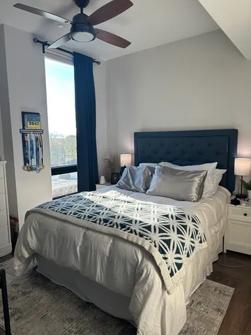 a bedroom with a bed next to a window with a chandelier