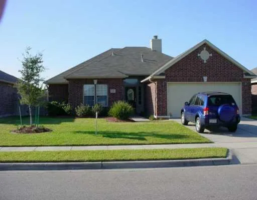 a front view of a house with a garden and trees