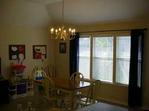 a view of a dining room with furniture and chandelier