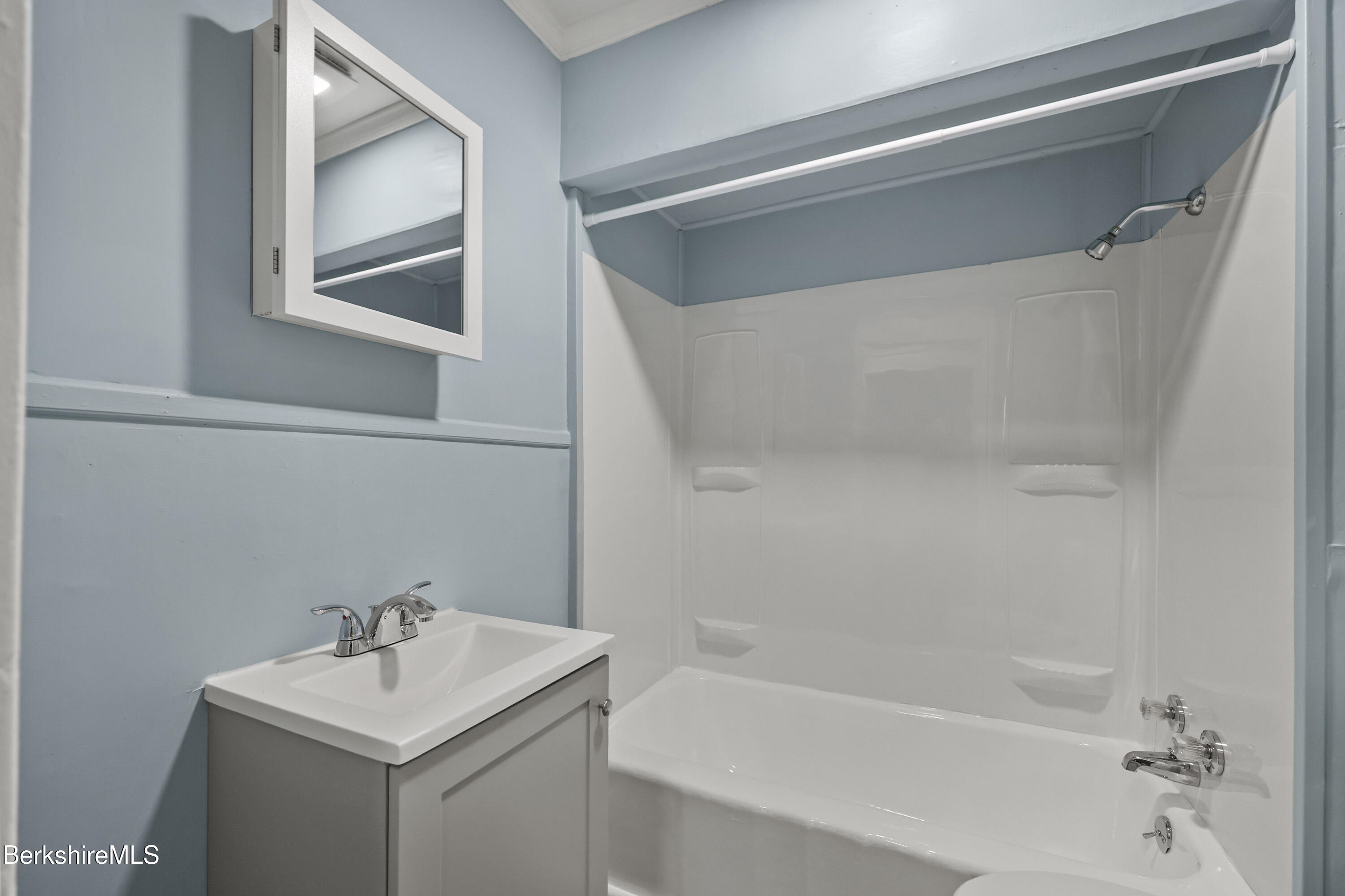 41-43 Reed Street Pittsfield, MA 01201 - Photo 22 of 56 a white bath tub sitting next to a white sink and a mirror