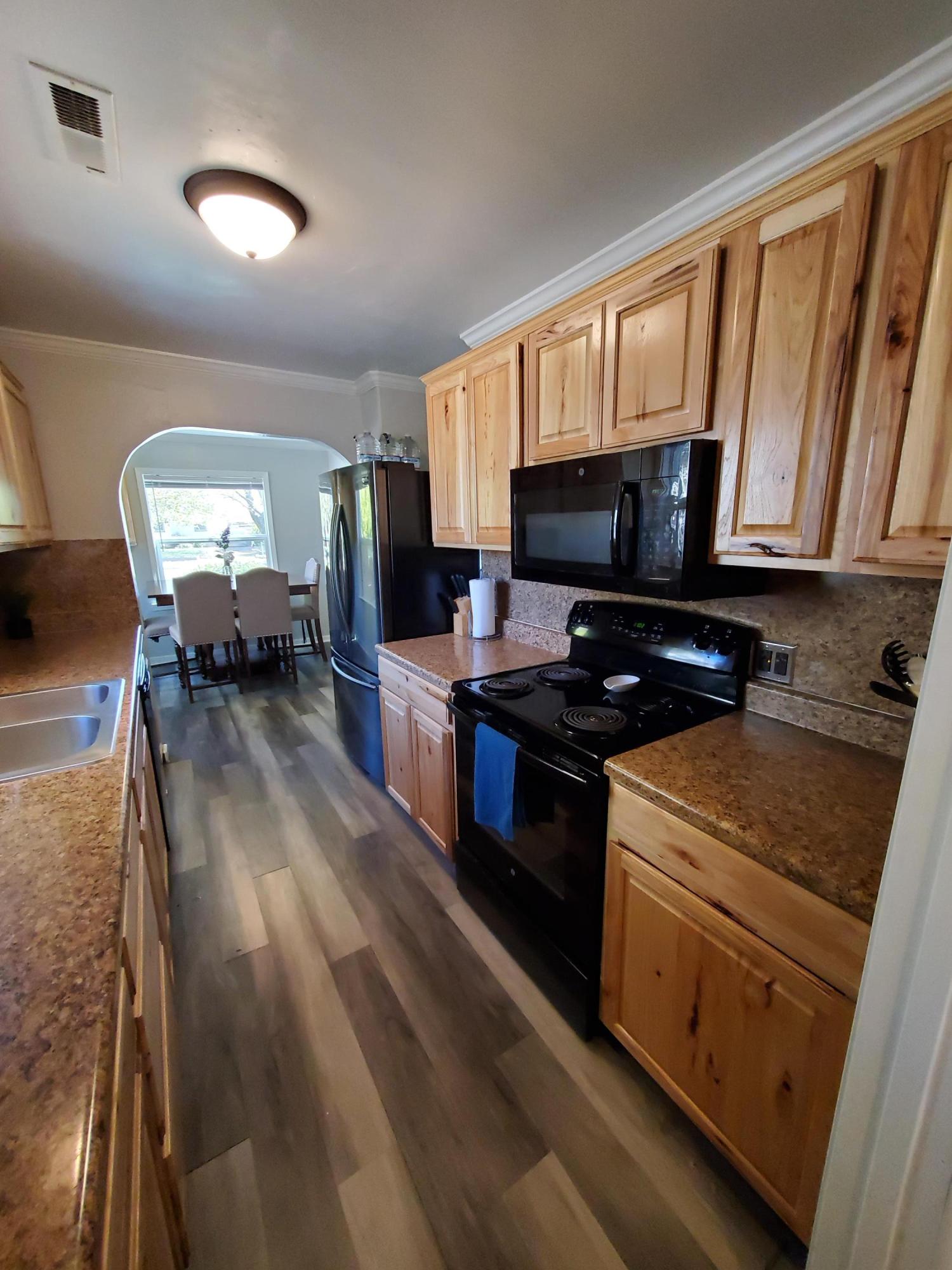 2476 California Street Redding, CA 96001 - Photo 25 of 32 a kitchen with granite countertop a stove a sink and a microwave